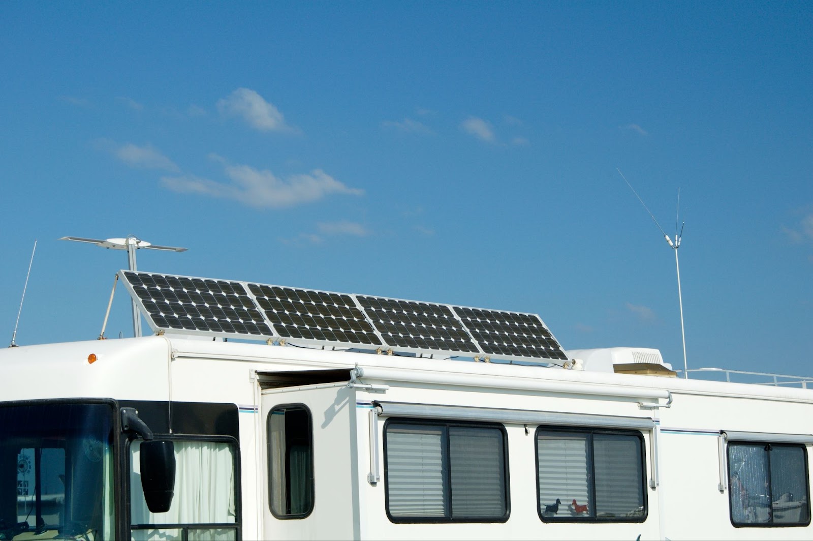 4 solar panels tilted on roof of RV